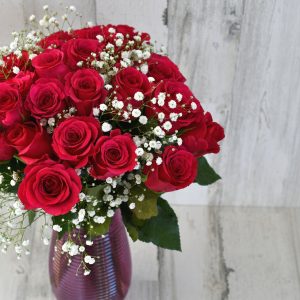 A bouquet of two dozen red roses with baby's breath floral arrangement, florist bouquet