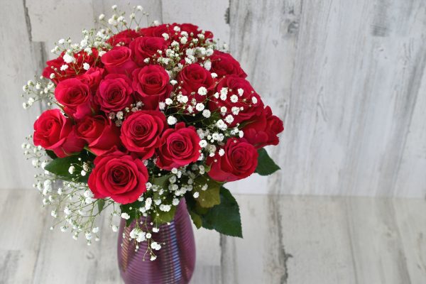 A bouquet of two dozen red roses with baby's breath floral arrangement, florist bouquet